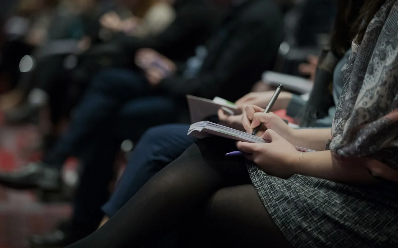 Conference attendee taking notes during a session.