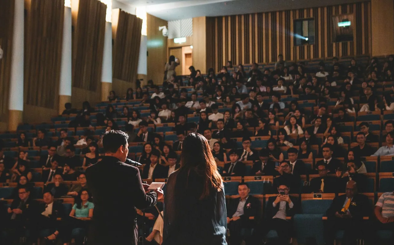 Large audience seated in a conference auditorium.